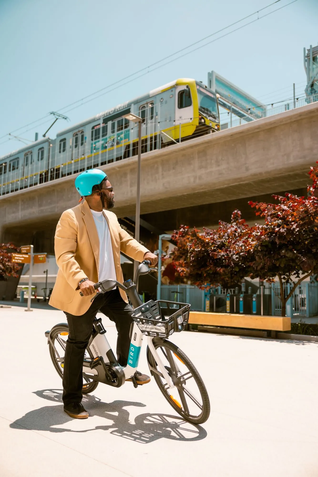 Two people standing together next to a Bird e-bike on a sunny path